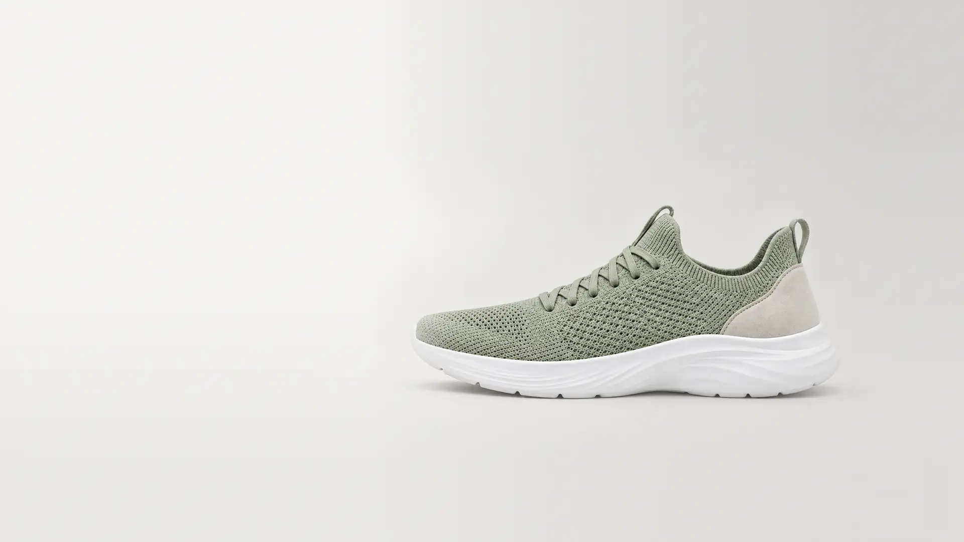 Produktbild: en salviagrön sneaker i stickat mot en ljusgrå studiobakgrund